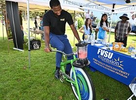 Justen Perry, a senior biology major from Columbus, Georgia, mixes a smoothie on one of the smoothie bikes at the Farmers, Landowners and Ranchers Outreach Conference held in September.    