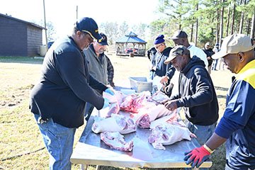 Terrell Hollis, FVSU meat plant manager (left) and his staff process a hog on site during the Flint River Farm Heritage Day celebration.