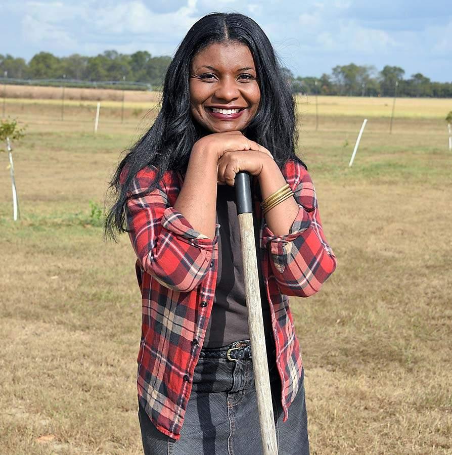 Hephzibah Beulah, a non-traditional student at Fort Valley State University, leans on farm implement at FVSU's holistic organic farm