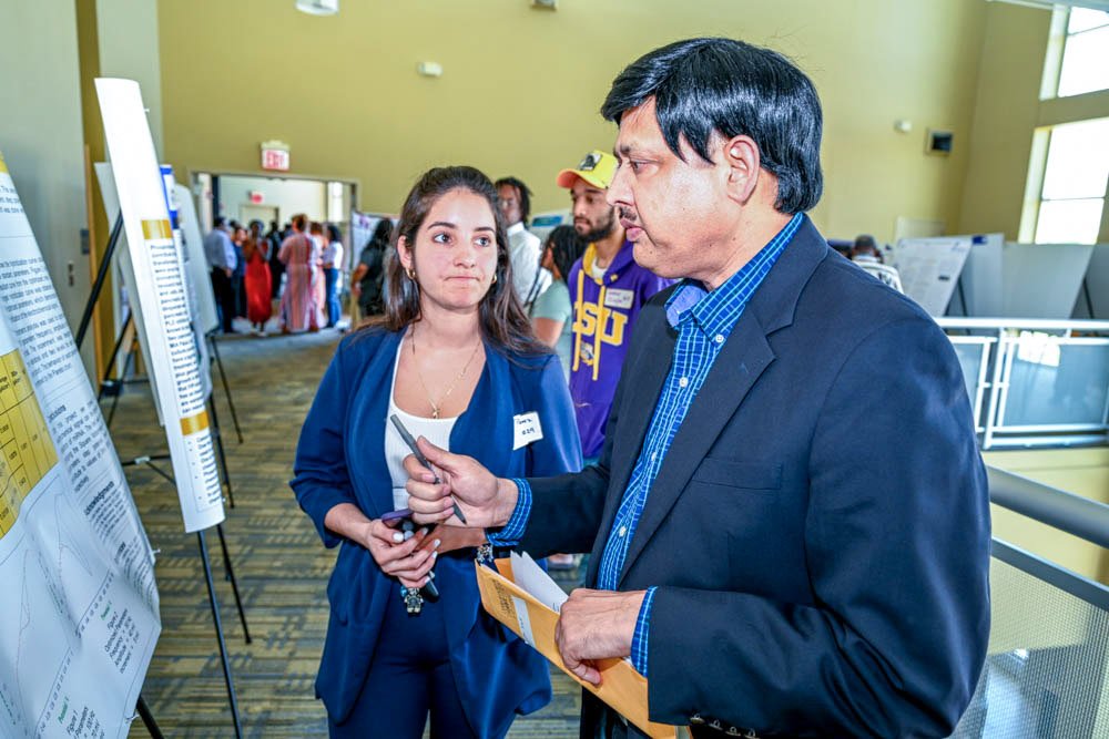 Dr. Hari Singh, professor in the Department of Agricultural Sciences, reviews poster presentation by Marian Perez, 2023 plant science biotechnology graduate and valedictorian, at the 2023 FVSU Research Day.