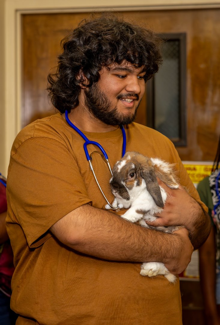 Leonel Orozco-Escalante beams as he carefully holds a rabbit.