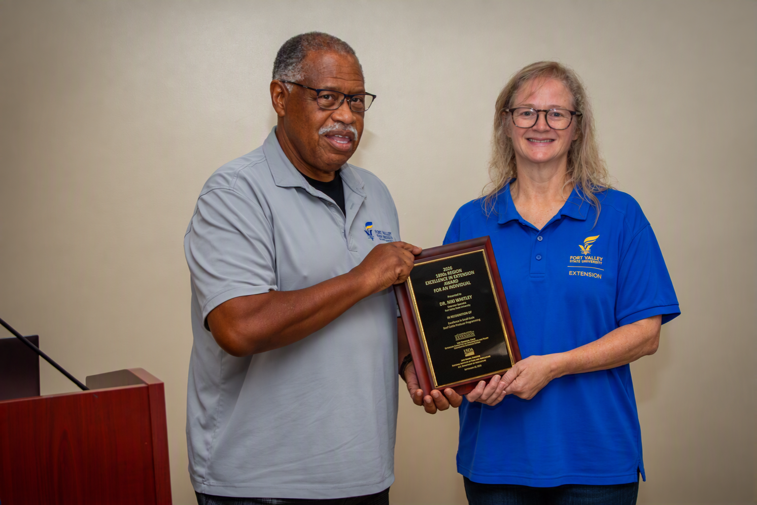 Latimore and Whitley holding plaque