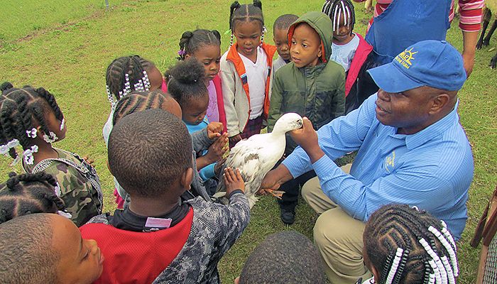 Program Assistant Chris Sanders with a duck and small children