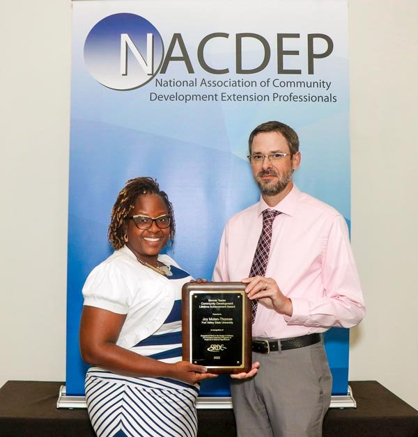 Joy Moten-Thomas (L), assistant administrator for community development and outreach for Fort Valley State University’s Cooperative Extension, recently earned the Bonnie Teater Lifetime Achievement Award sponsored by the Southern Rural Development Center. Dr. John Greene, director of the Southern Rural Development Center presents her with a plaque.