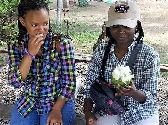 Fort Valley State University junior LaShombria Ellerbee (right) samples a fresh custard apple before field work with students at the Universidad Nacional de Agricultura (UNA) in Catacamas, Honduras.